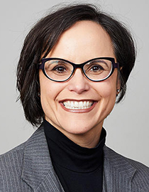 portrait of a person with glasses and dark hair smiling