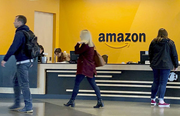 People walking in foreground of Amazon reception desk