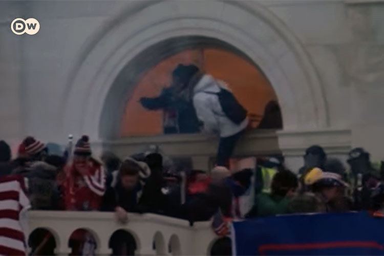 Rioters entering the U.S. Capitol through a broken window
