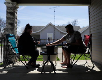 A couple in Greensburg, Indiana plays a card game on the front porch