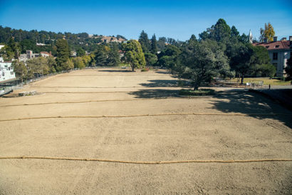 A photo of a large open lot, surfaced in sand, on the UC Berkeley campus.