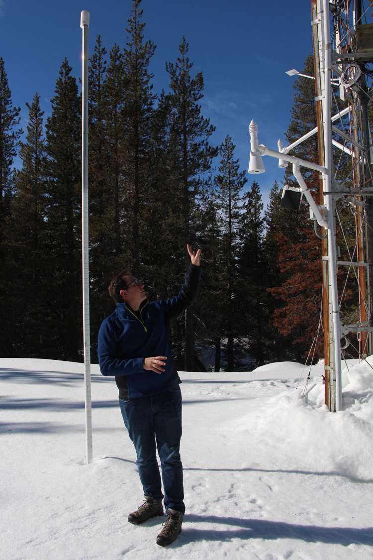 man pointing to snow measurement instruments