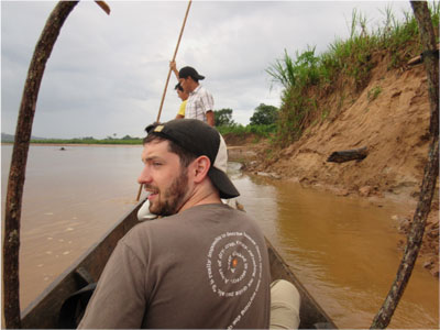 Harvard postdoctoral researcher Stephen Ferrigno sitting in a boat on the Amazon river in Bolivia.
