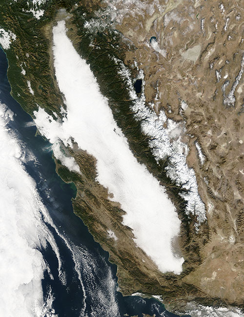 A satellite image of the Central Valley of California, showing thick white clouds in the valley