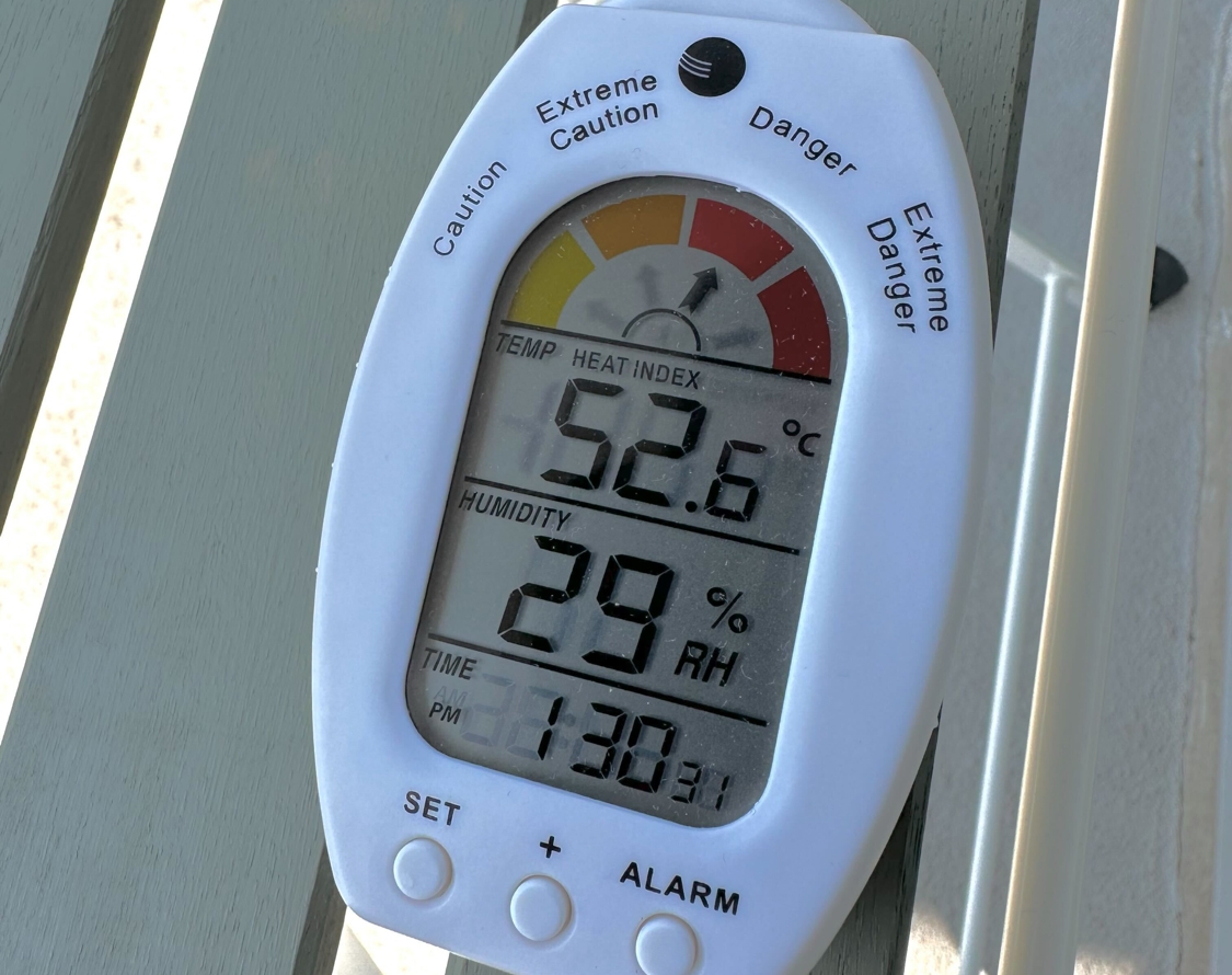 white plastic digital device showing temperature, humidity and heat index