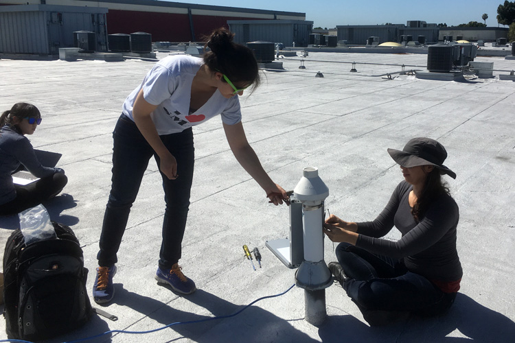 three women installing pollution sensors