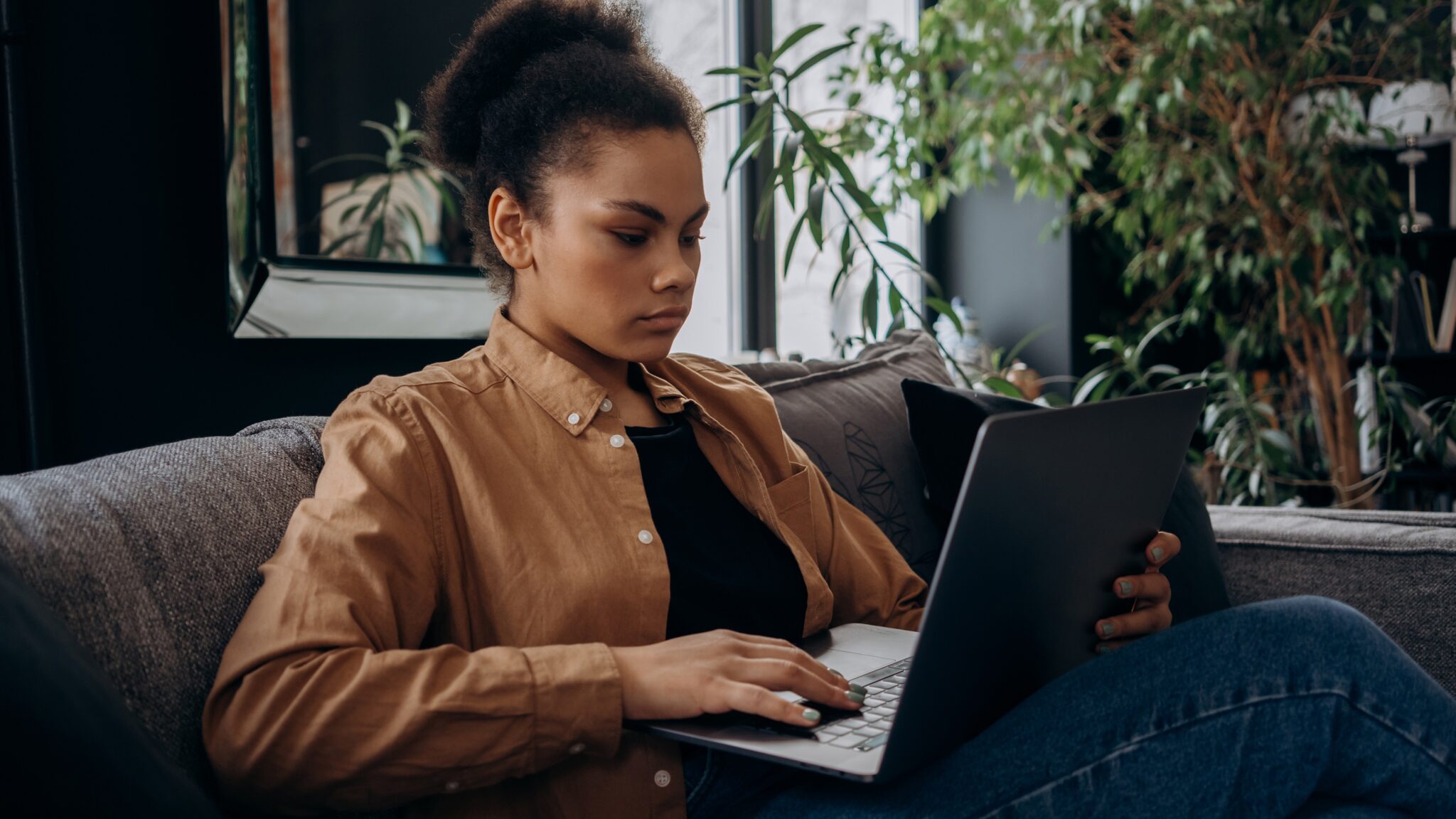 image of woman on the couch on her laptop