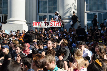 Protesters on UC Berkeley campus with sign "Here to Stay"