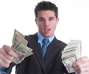 stock photo of a man in a suit flaunting cash.