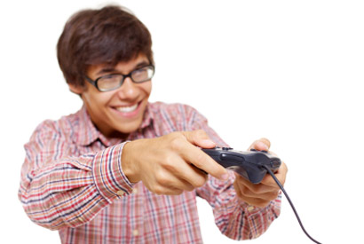 Stock photo of a man with glasses playing on a video game console.