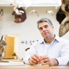 Justin Bashares in lab with taxidermy animals