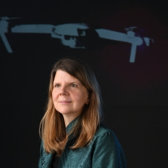 Claire Tomlin standing in front of a project of an aerial device