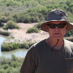 Mathias Kondolf wearing hat and holding notebook at the Bill Williams River in Arizona