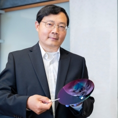 Junqiao Wu holding lens with his reflection