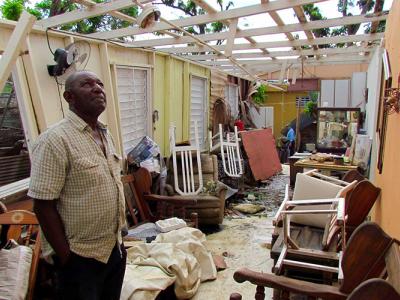 a person looks at his house in Puerto Rico that was destroyed by a hurricane