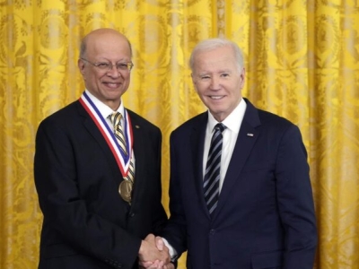 Photo of Ashok Gadgil, wearing the National Medal of Technology and Innovation, shaking hands with President Biden.
