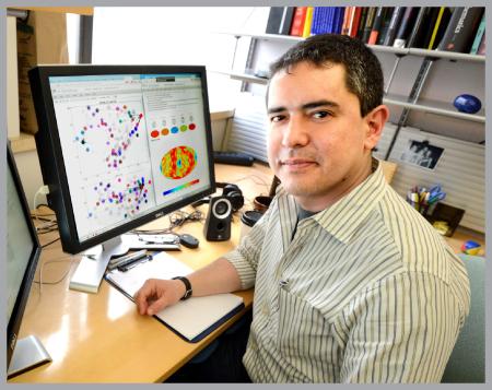 Fernando Perez sitting at desk with models on computer monitor in front of him.