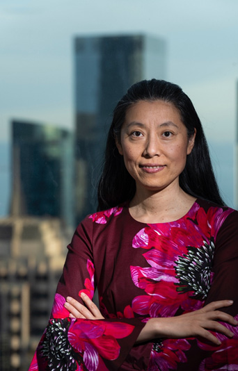 Dawn Song standing with arms crossed in front with cityscape in background