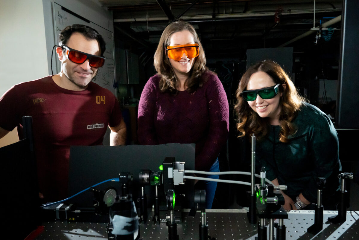 UC Berkeley professors Hillel Adesnik, Laura Waller and Rikky Muller pose with a technical device in a lab.