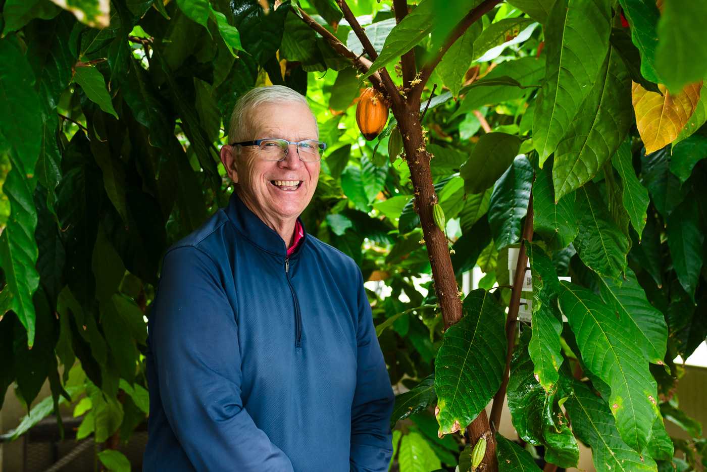 image of man smiling with trees and leaves in the background