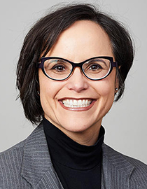 headshot of woman in glasses smiling