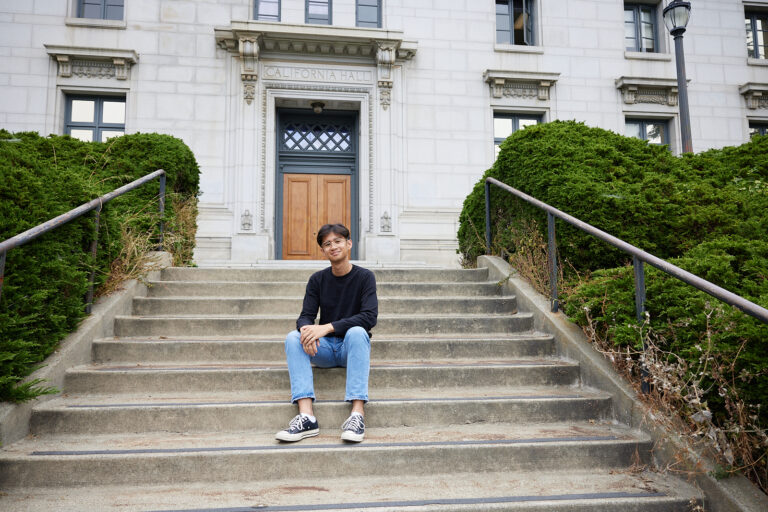 image of man sitting on steps in front of California Hall