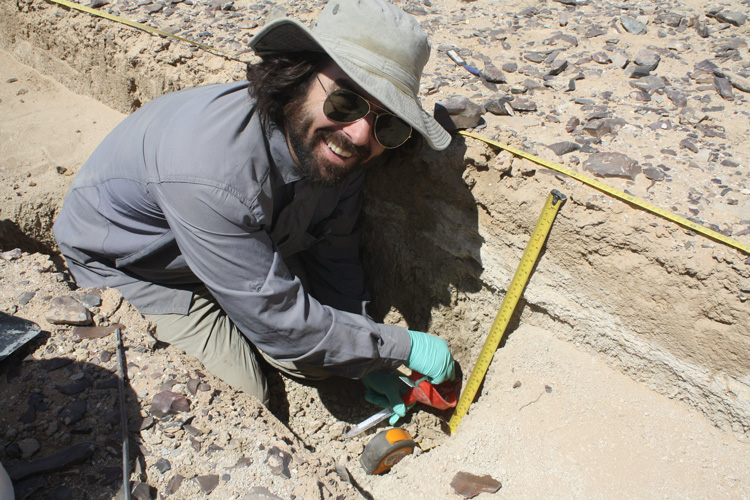 an image of aj white examining an archaeological dig 