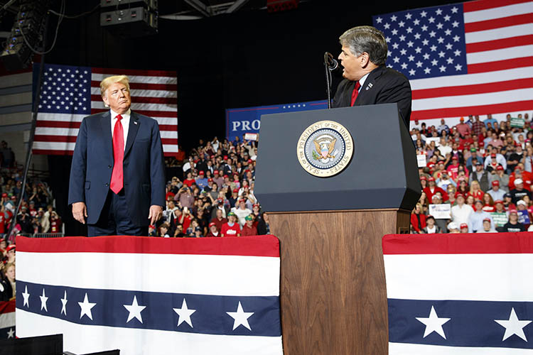 President Donald Trump listens to Fox News' Sean Hannity