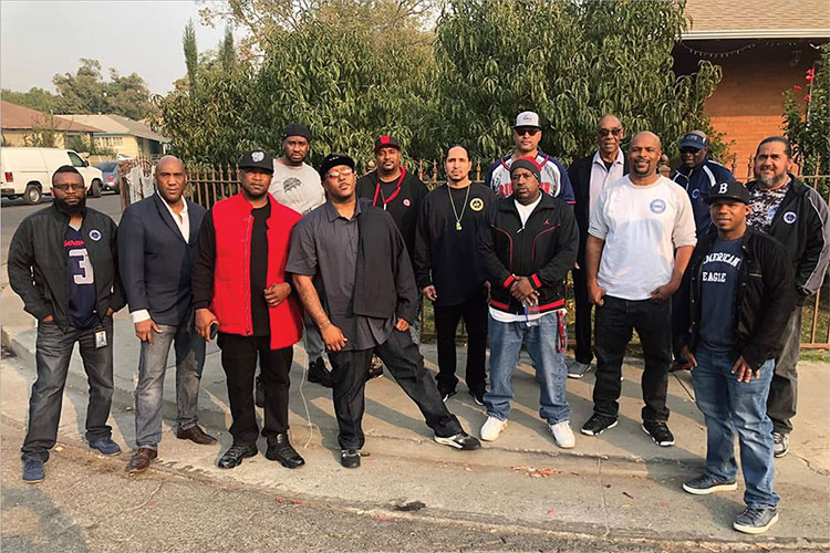 A group of men pose in a Stockton neighborhood