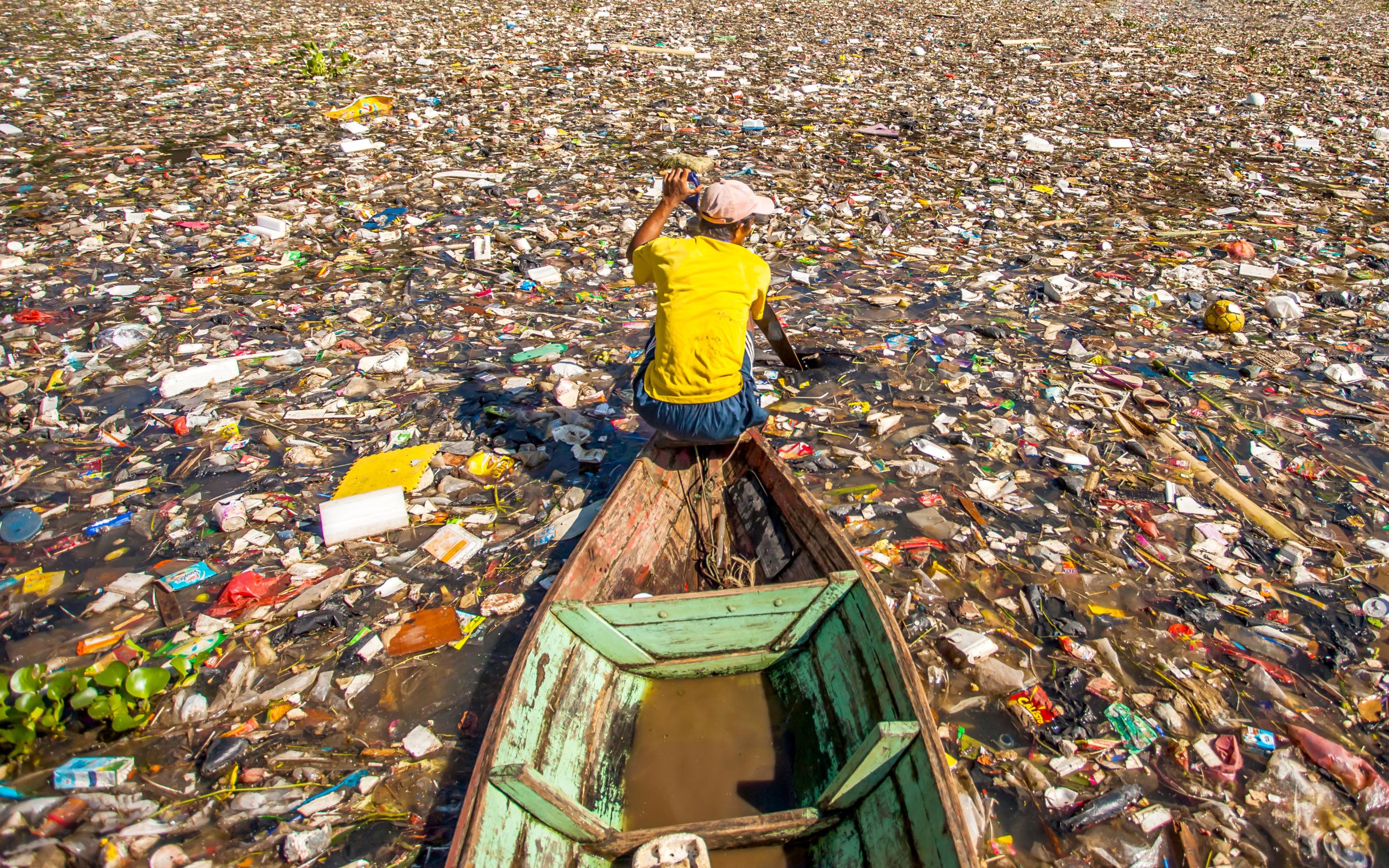 People collect trash that can be recycled and traded from the sea of garbage in the Citarum River, the one of polluted river in Bandung, West Java, Indonesia.