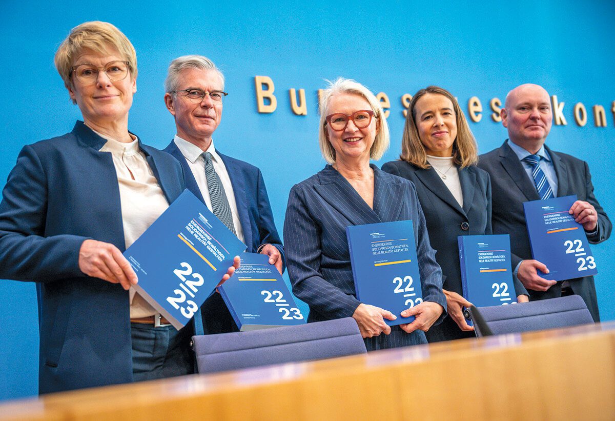Five people standing holding their annual reports 