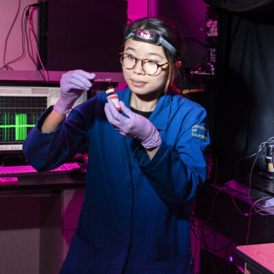 woman in lab caot holding something in hand