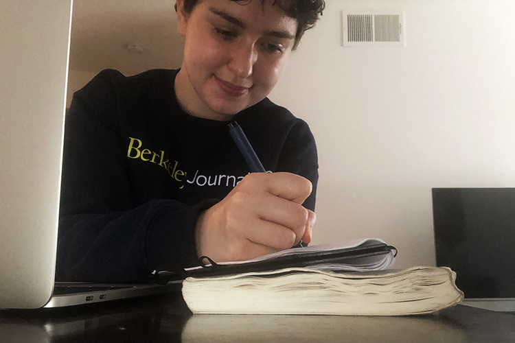 Annie Berman sitting at a desk taking notes