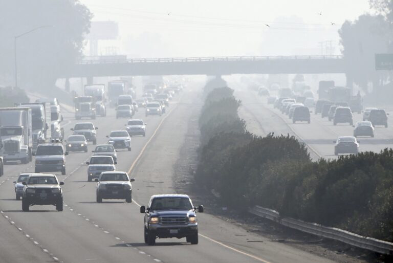 Cars drive through smoggy air on a California highway