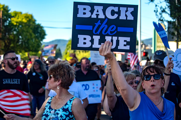 Pro-police Blue Lives Matter protesters, with one carrying "Back the Blue" placard