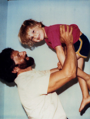 Chesa Boudin as a young child being lifted by his father