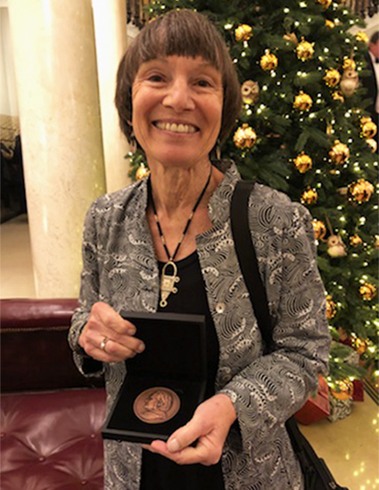 Margaret Conkey holding the Thomas J. Huxley Memorial Medal