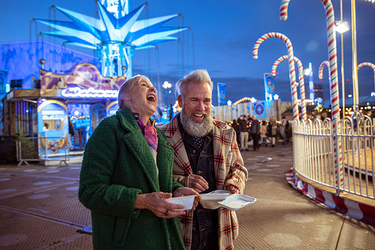 Older couple having fun together at a fairground carnival.