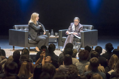 U.S. Supreme Court Justice Ruth Bader Ginsburg talks on stage while sitting in a black chair