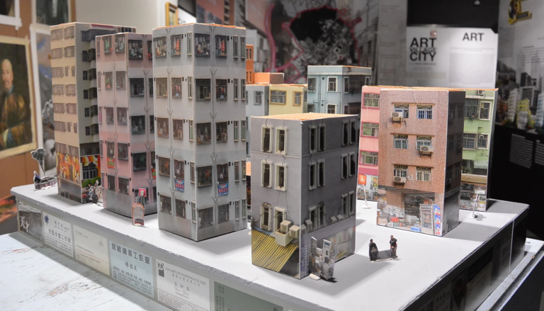 A small model of about a dozen tall buildings inside the gated village of Dafen
