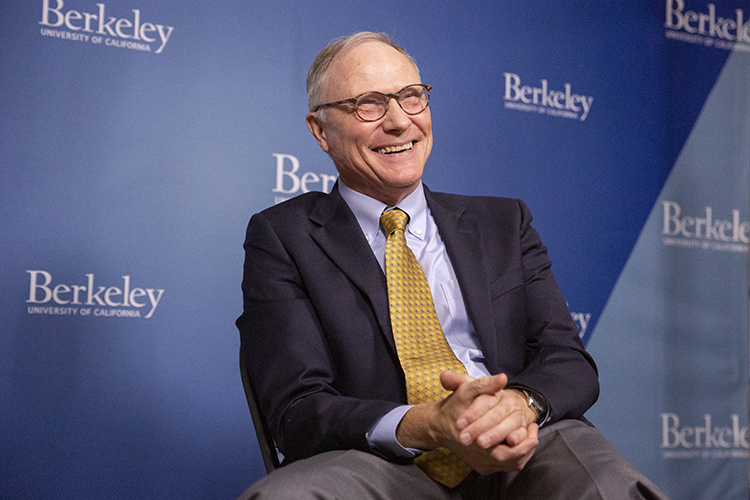 David Card smiles behind his eyeglasses and clasps his hands together while discussing news of his Nobel Prize win.