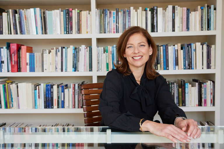 image of woman sitting at a table and smiling