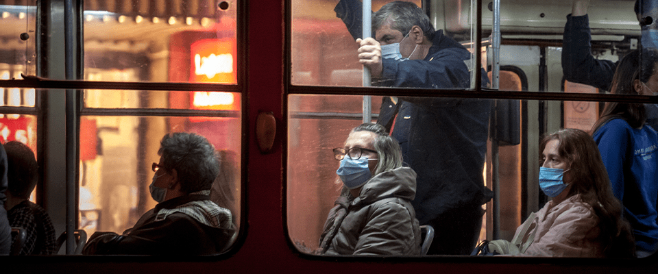 People riding public transportation wearing masks