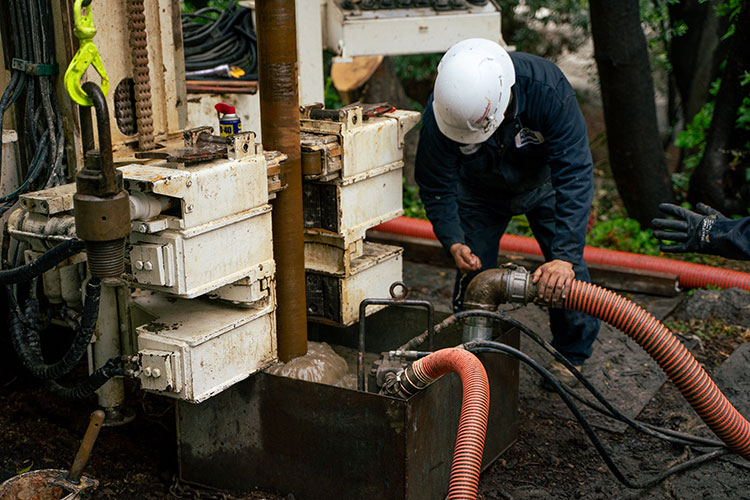 A photo shows a person operating a large drill