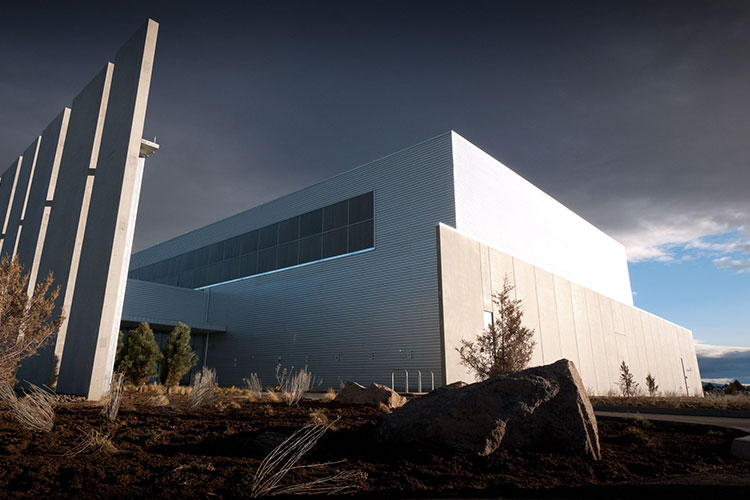 a 2011 photo of a single building at Facebook's data center in Prineville, Oregon, a windowless facade lit by late-day sun
