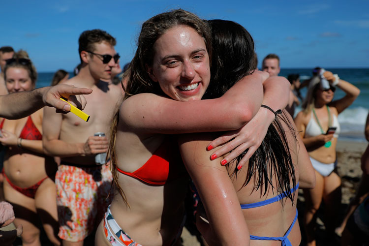 Two spring revelers hug on Pompano Beach in Florida.