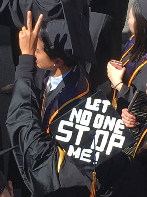 Graduate with "Let no one stop me" message on hat