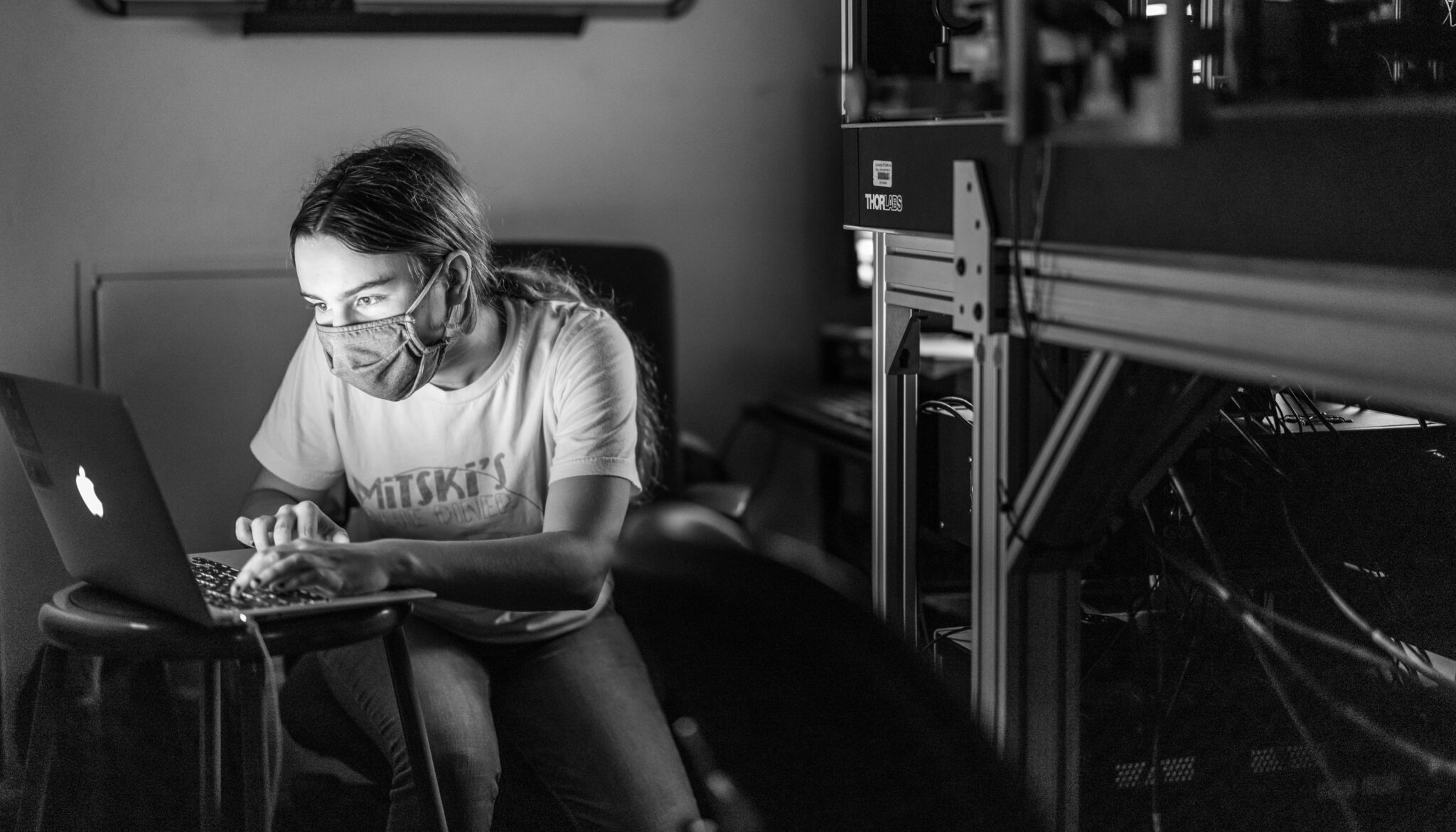 black-and-white photo of Ph.D. student Hannah Doyle using a laptop in a lab