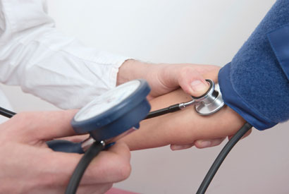 Health care provider taking patient's blood pressure.