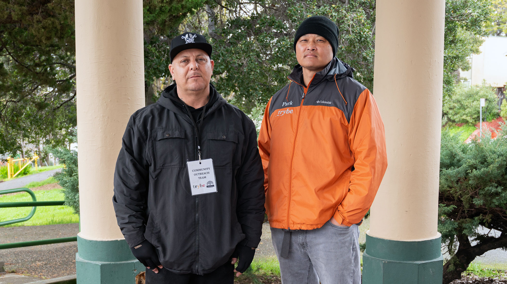 Hector Cruz, at left, stands with Andrew Park in the shelter of a pavilion at San Antonio Park in Oakland